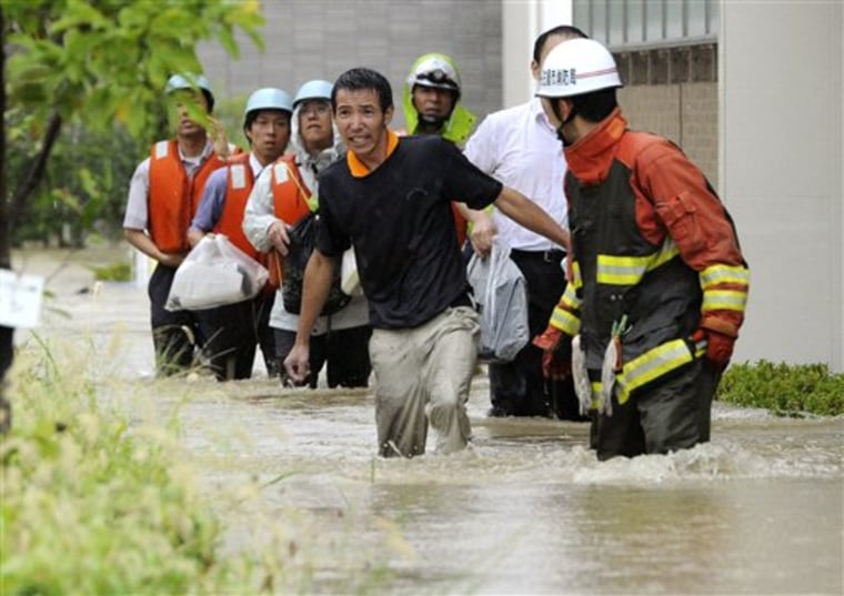 Residents wade through a flooded street caused by an approaching typhoon in Nagoya, Japan, on Tuesday.